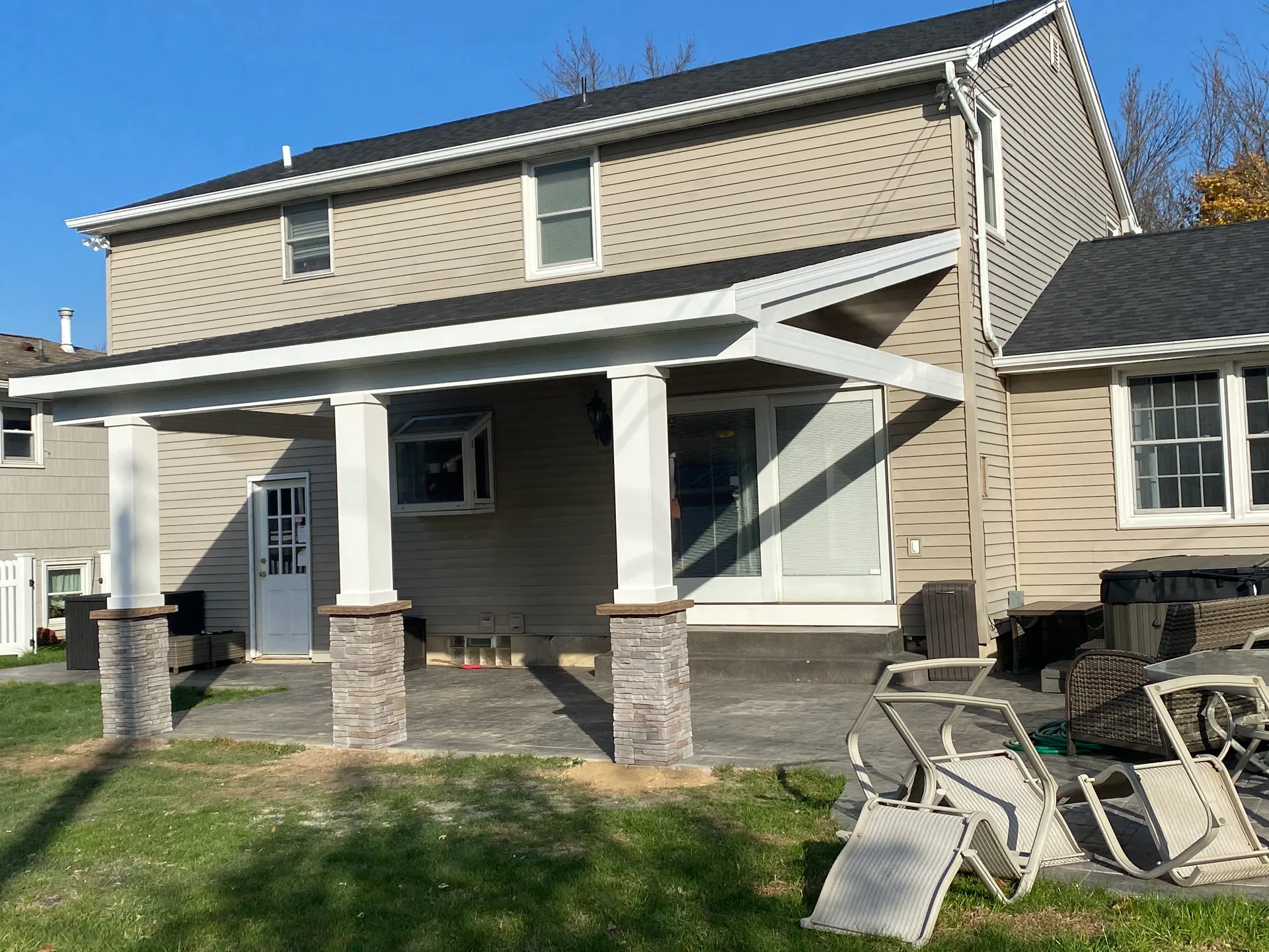 backyard covered patio roof white columns stone bases silver springs