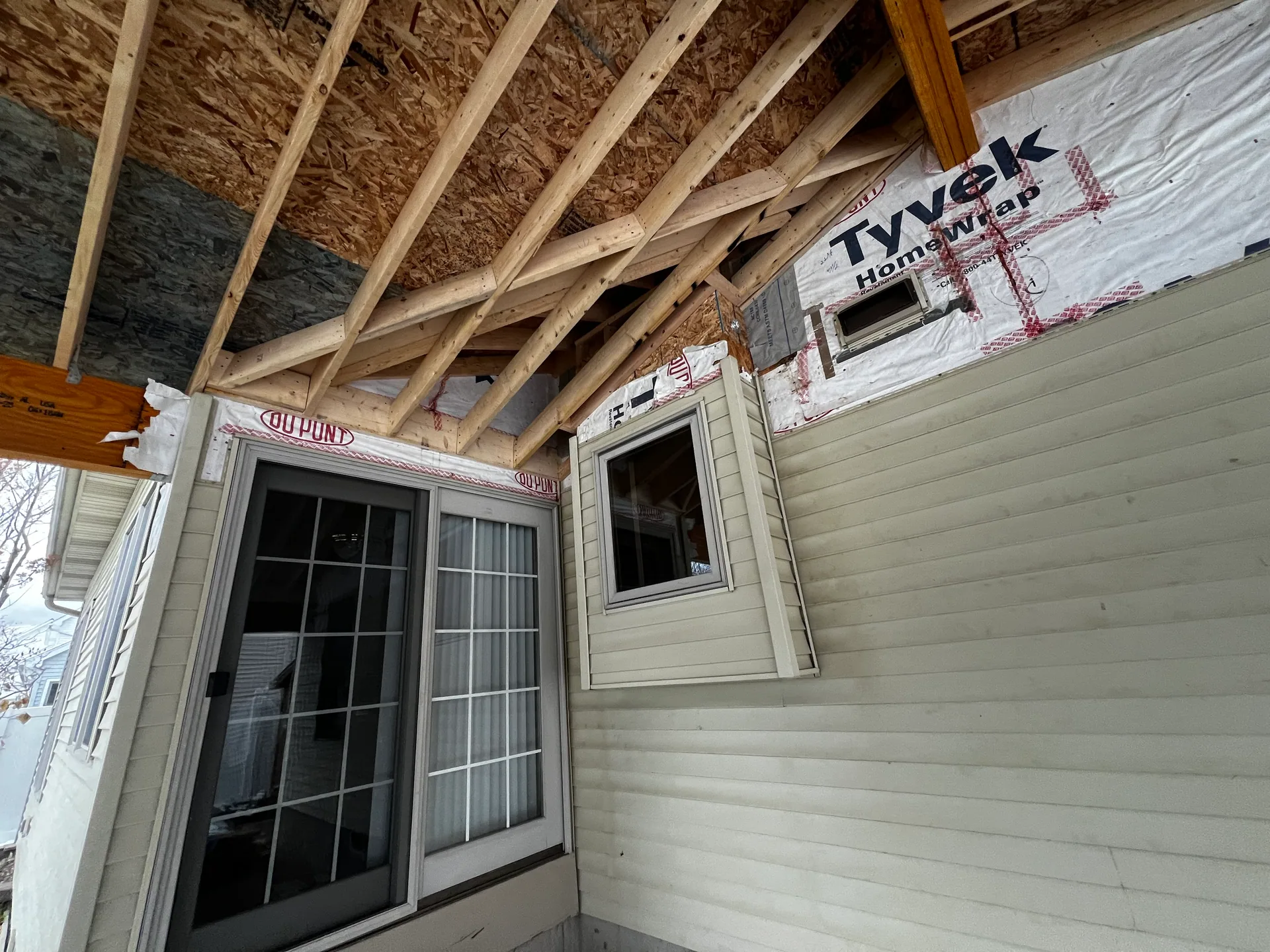 corner roof rafters tyvek wrap sliding door window beige siding silver springs