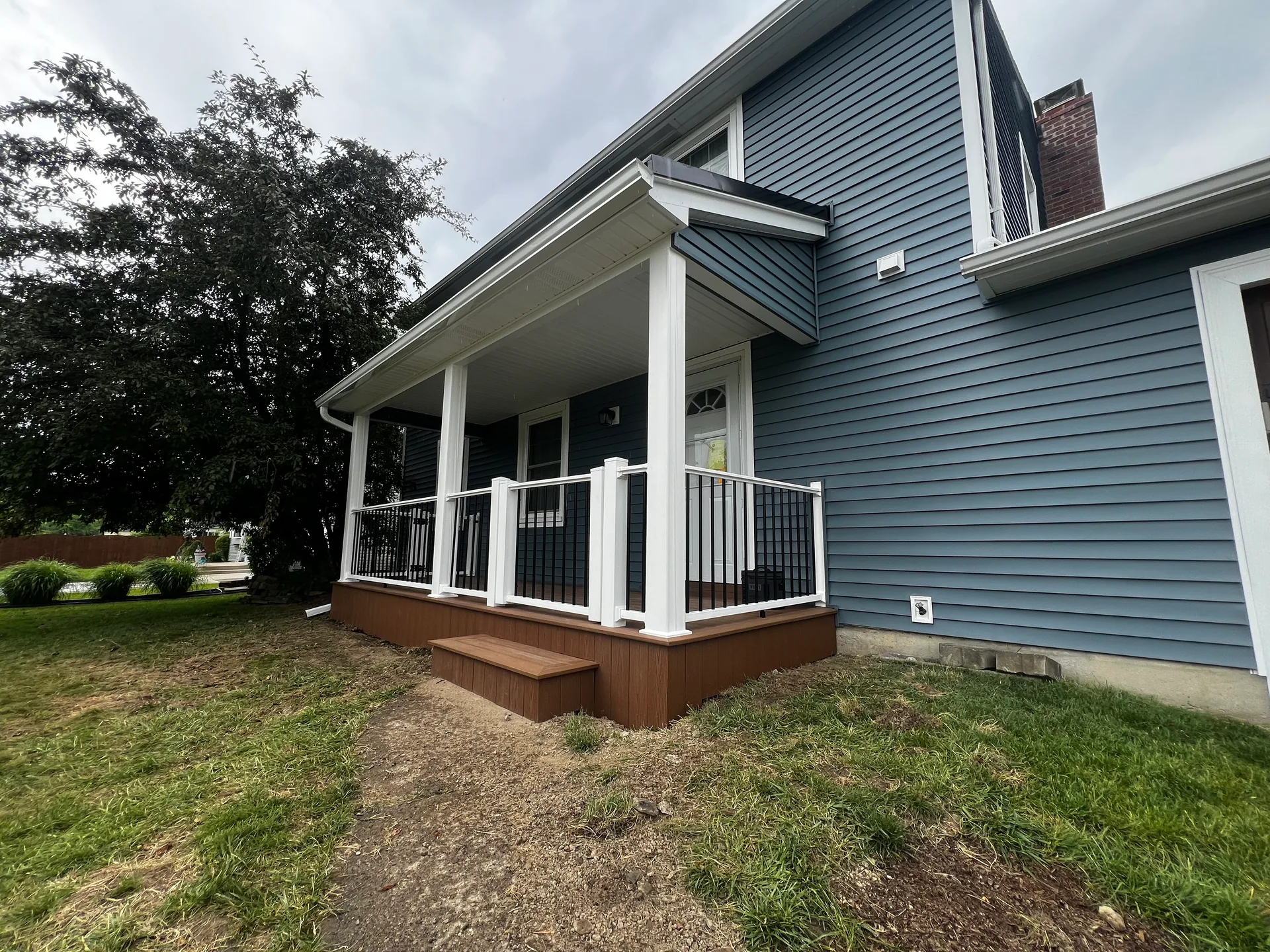 corner view new front porch brown composite step blue siding silver springs