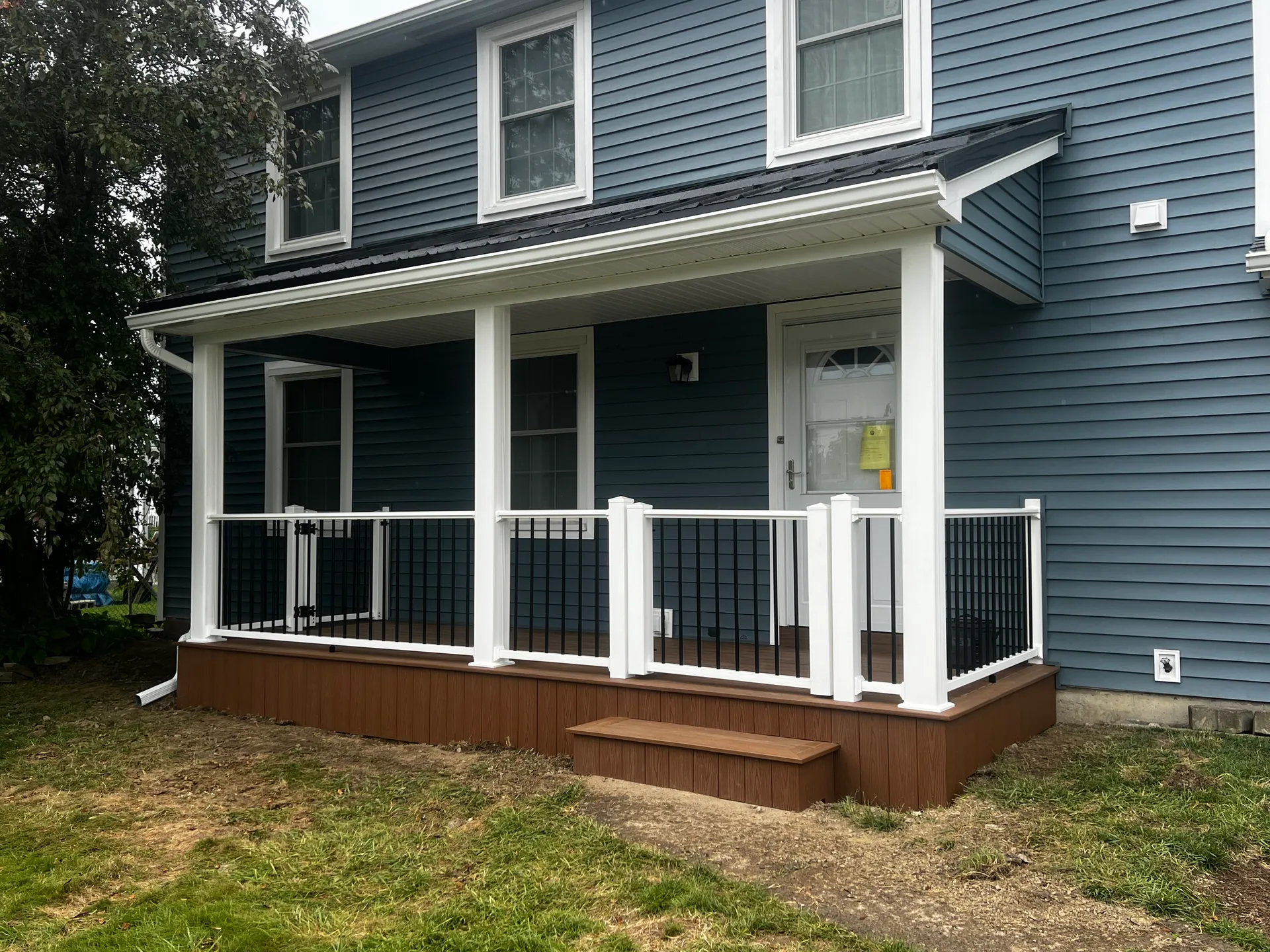 covered front porch brown composite skirt black balusters gate silver springs