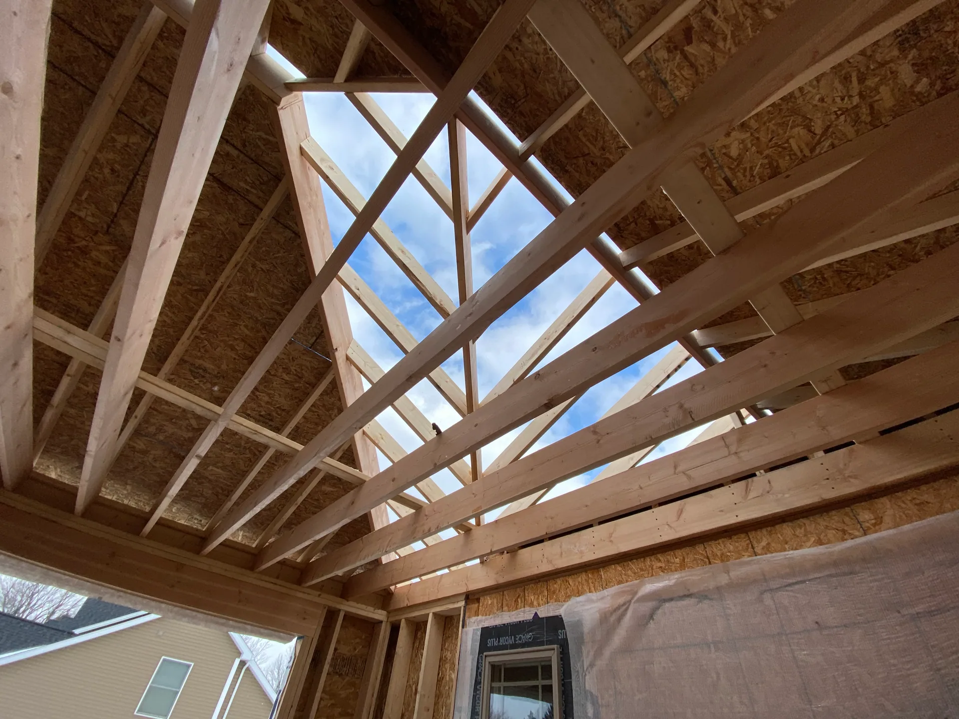 looking up open roof framing rafters blue sky room addition amherst ny