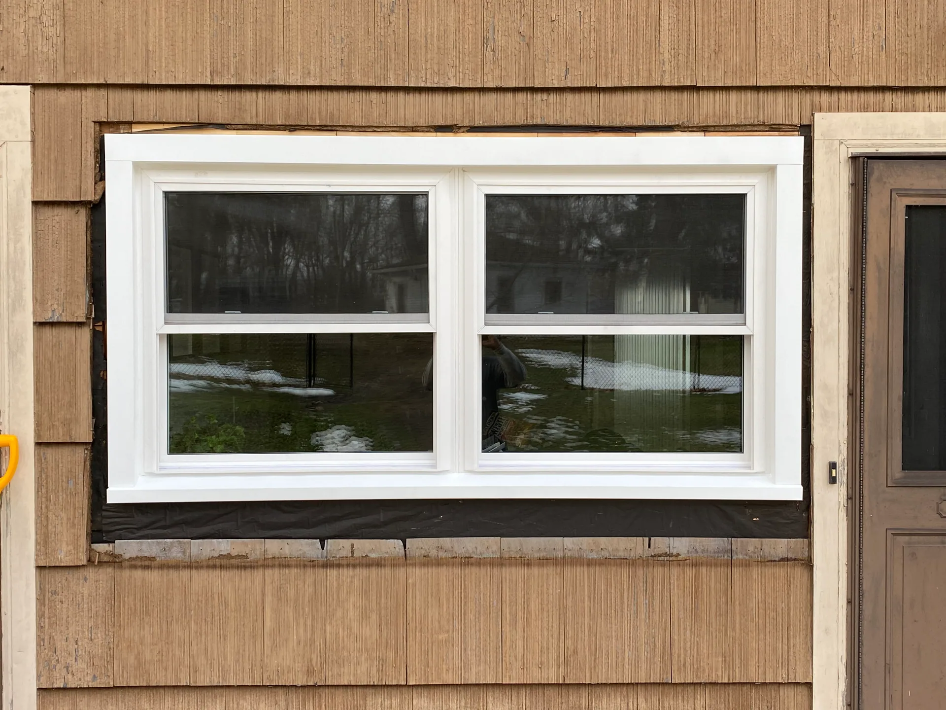 paired white vinyl windows exposed house wrap cedar shake siding east aurora
