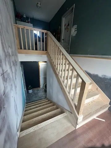 two flight pine staircase landing railing teal wall hardwood floor tonawanda ny
